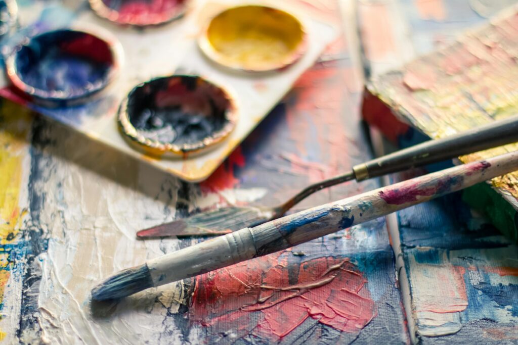 Vibrant close-up of paintbrushes and a palette on a textured canvas showcasing creativity.creative art activities preschool