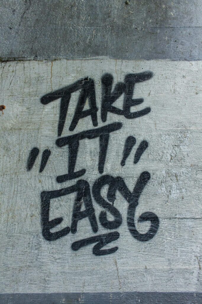 Black graffiti text 'Take it Easy' on a textured concrete wall.Creative Design Blogs