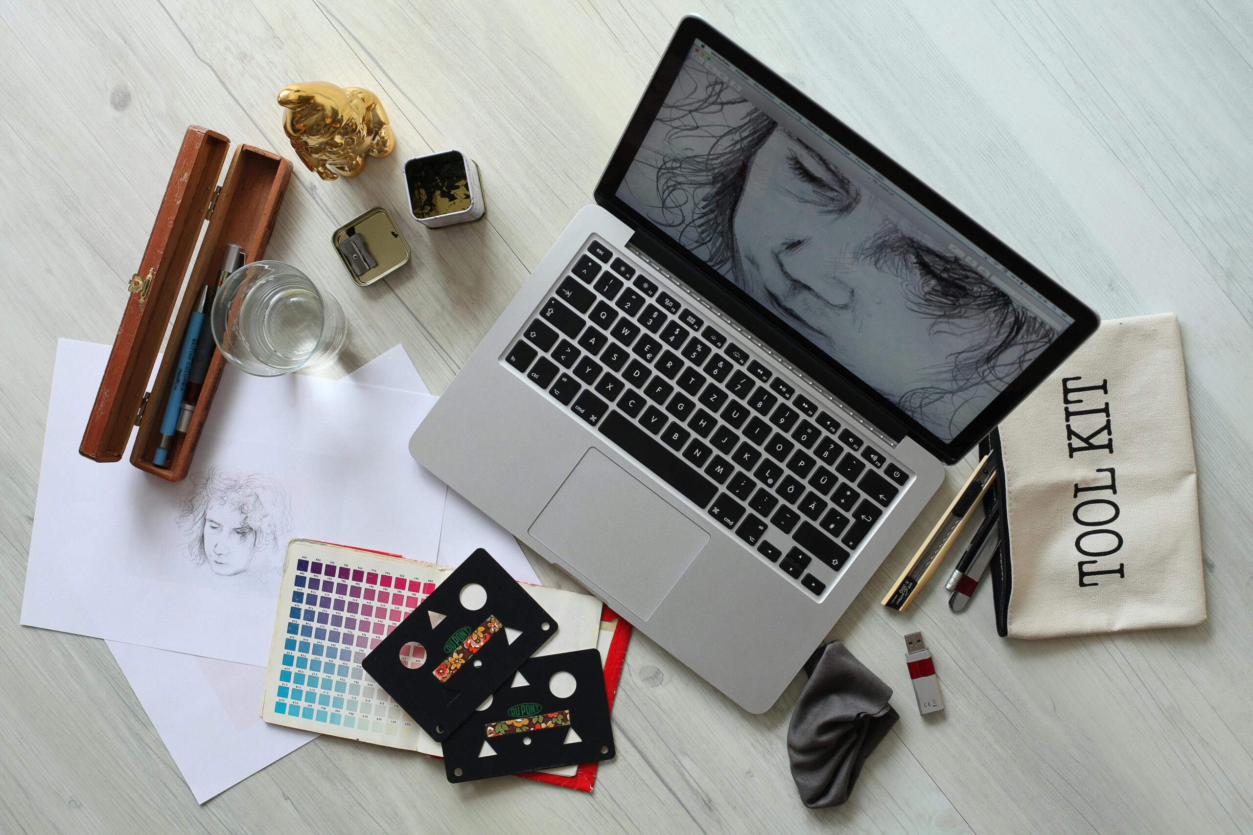 Top view of a creative workspace with a laptop, sketch supplies, and color palette.art design for project