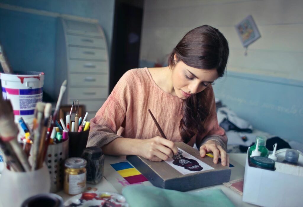 Female artist deeply engaged in painting at her creative studio workspace. art design drawing